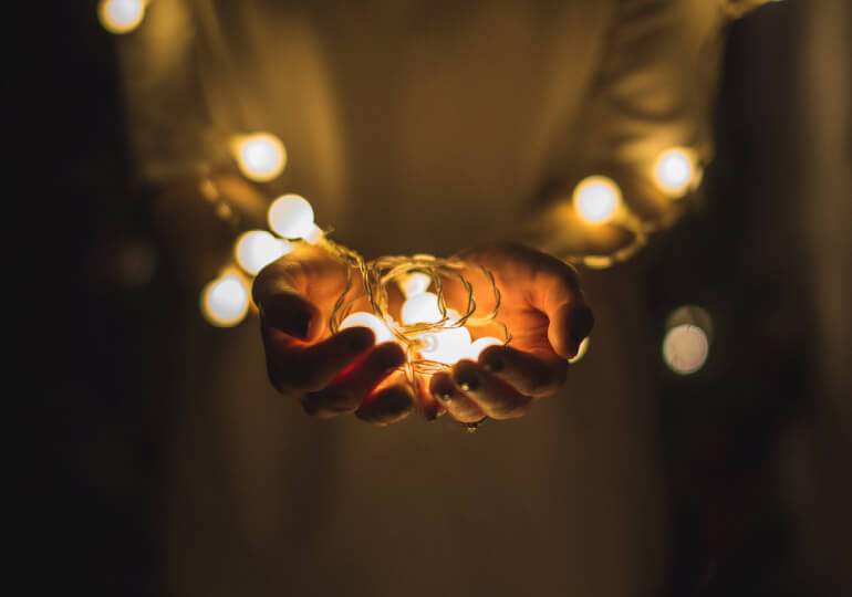 Person holding a string of lights