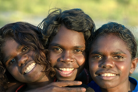 three aboriginal children faces smiling