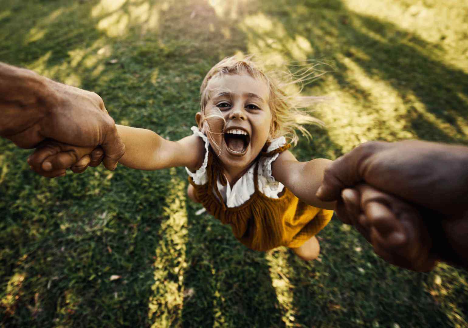 Young girl with hands held and swinging for fun